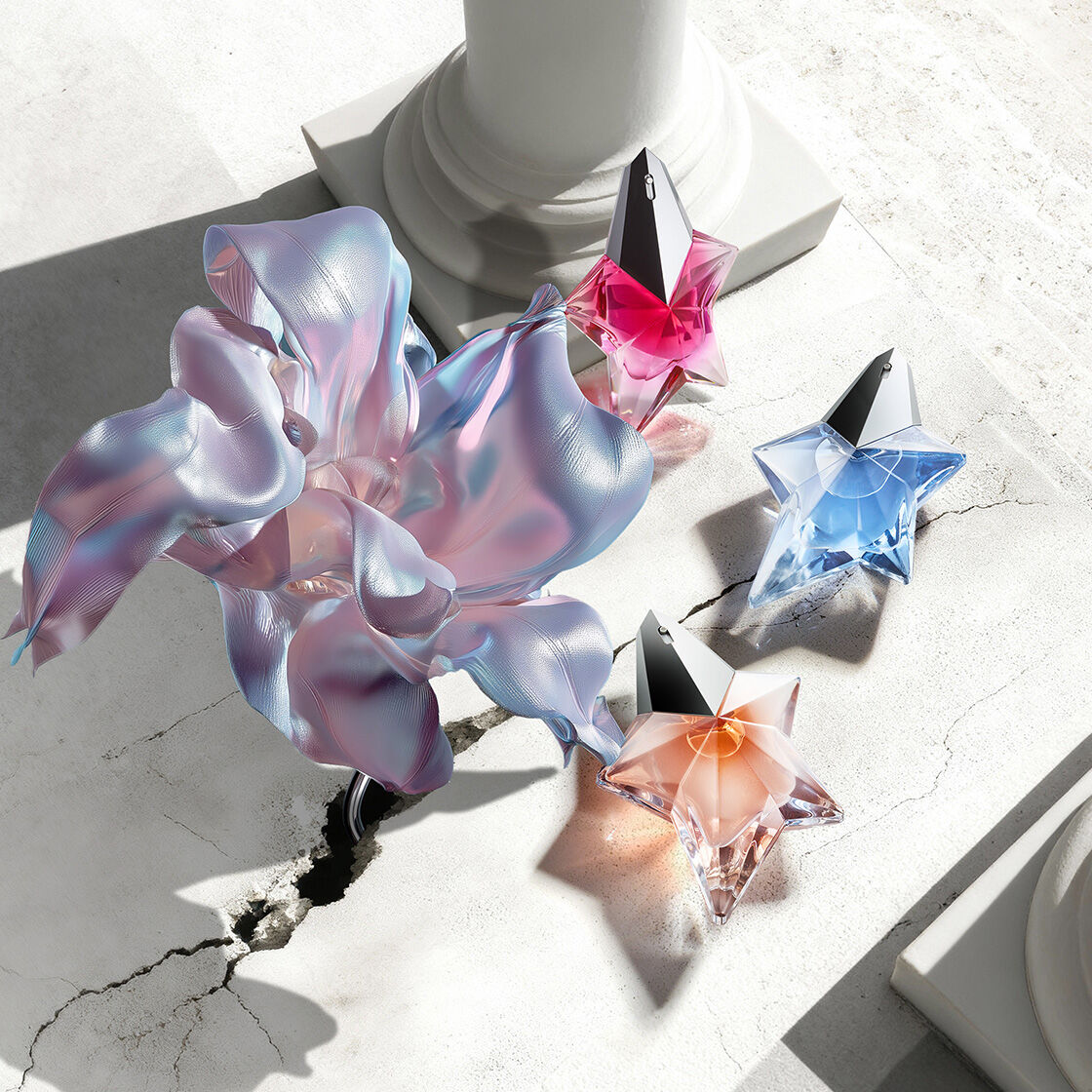 Bannière de la campagne Mugler pour la Fete des Mères 2026, mettant en scène les flacons emblématiques de la gamme de parfums Angel dans un décor floral céleste et un paysage parisien, en hommage aux mères exceptionnelles.